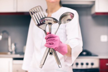 Parlayan metal aletler ve ev temizleme servisi olan bir kadın.