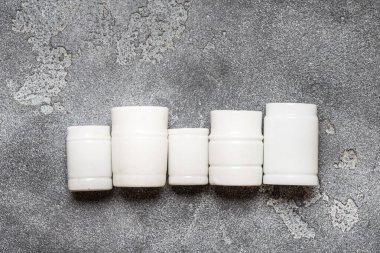 Beyaz porselen laboratuvar kavanozları, koyu gri çanak çömlekler.