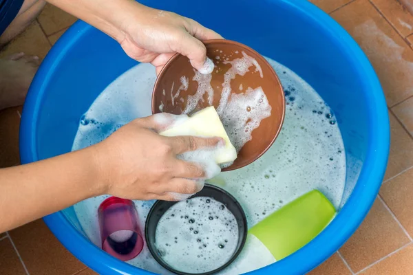 Женщины мыли посуду руками в раковине — стоковое фото