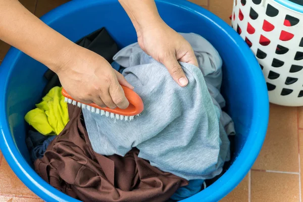 Женщины отделяют одежду от корзины в раковину, моют руки Стоковая Картинка