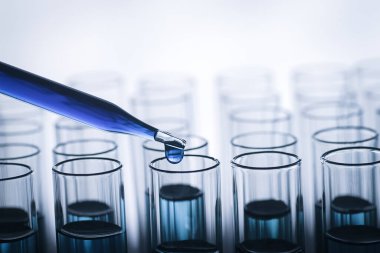 Laboratuvardaki deney tüpünün üzerinde borular, laboratuvar deneyleri için kimyasal örnekler bırakıyor.