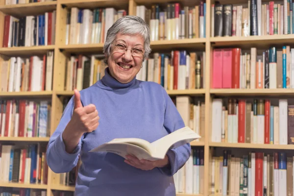 Czytanie książek w domu starszy kobieta. Kciuki się zmotywowani expres — Zdjęcie stockowe