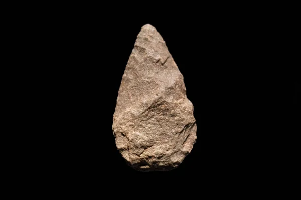 Ferramenta humana pré-histórica, biface de quartzo sobre fundo isolado preto, 500.000 anos . — Fotografia de Stock