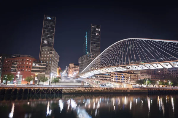 Puente zubizuri peatonal y paisaje urbano de Bilbao por la noche, Bilbao — Foto de Stock