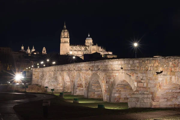 Vista nocturna de la catedral de Salamanca y puente romano sobre Tormes r — Foto de Stock