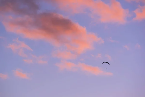 夕暮れ時にシルエットをパラグライダーで飛ぶ — ストック写真