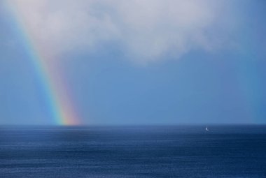 Güzel gökkuşağı ve tekne okyanus ufukta
