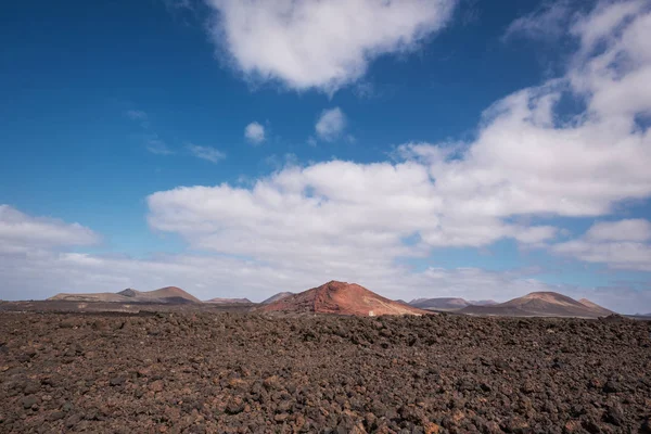 Κόκκινο ηφαιστειακό τοπίο, λάβα σκηνικό με κρατήρα ηφαιστείου στο παρασκήνιο — Φωτογραφία Αρχείου