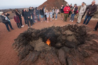 Lanzarote, İspanya - 12 Şubat 2018: Turist izlerken yangın gösteride Timanfaya volkanik Milli Parkı Lanzarote, Kanarya Adaları, İspanya. 