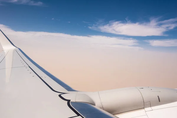 Flygplansvinge och turbin detalj över molnen — Stockfoto