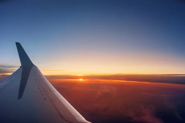 Asa de avião durante um pôr do sol vibrante — Fotografia de Stock