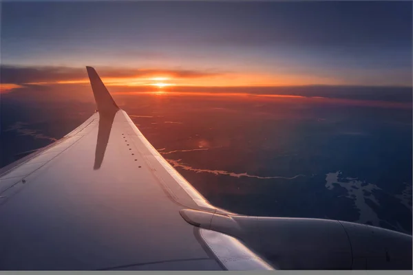 Asa de avião durante um pôr do sol vibrante — Fotografia de Stock