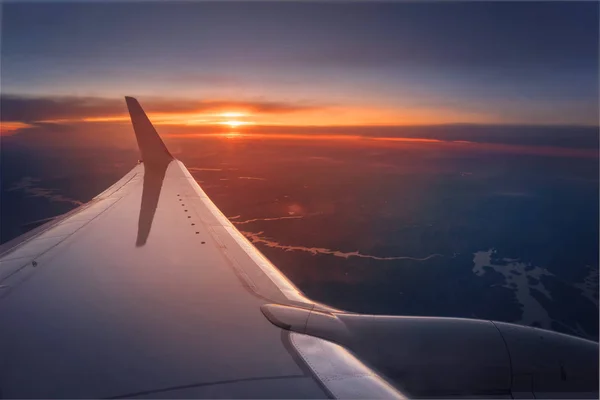 Flygplansvinge under en pulserande solnedgång — Stockfoto