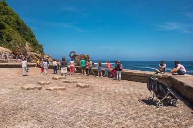 San Sebastian, Spain - June, 10, 2017: Tourist visiting famous landmark Peine de los Vientos in San sebastian, Basque country, Spain. clipart