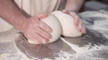 Profesyonel bir mutfakta deneyimli bir şef ekmek yapmak için hamuru unla hazırlar..
