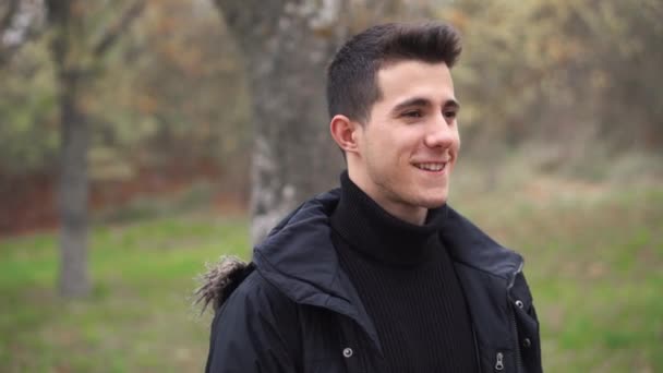 Retrato de un joven feliz sonriendo y riendo en cámara en el parque . — Vídeo de stock