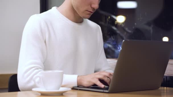 Jeune homme travaillant sur son ordinateur portable dans un café, jeune étudiant tapant sur ordinateur . — Video