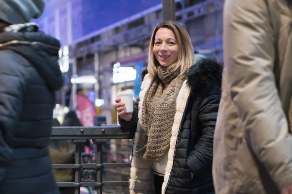 Žena s kávou na ulici. Krásná módní mladá žena s kávou v noci města. — Stock fotografie