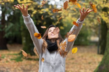 Mutlu Kadın Sonbahar Parkı 'na Yapraklar Fırlatıyor.