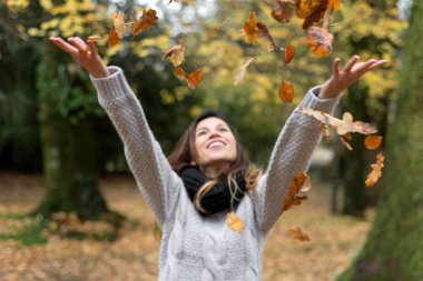 Mutlu Kadın Sonbahar Parkı 'na Yapraklar Fırlatıyor.