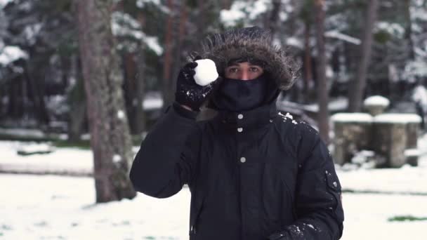 Mladý muž hraje sněhové koule s přáteli, zpomaluje. Kulečníková rvačka. Zimní zábava, aktivní volný čas. — Stock video