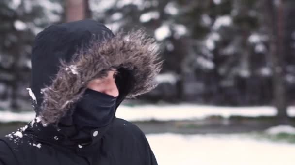 Joven jugando bolas de nieve con amigos, cámara lenta. Pelea de bolas de nieve. Diversión invernal, ocio activo . — Vídeo de stock