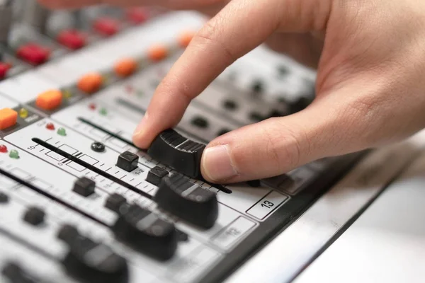 Mannenhand op besturingselement Fader van de console. Geluid opnamestudio desk mengen met ingenieur of muziek producer. — Stockfoto