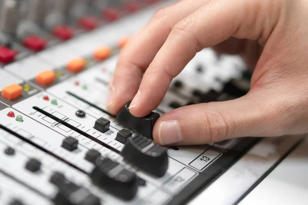 Mannenhand op besturingselement Fader van de console. Geluid opnamestudio desk mengen met ingenieur of muziek producer. — Stockfoto