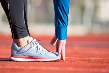 Yakın görüş, koşan bir pistte gerinen sporcu.