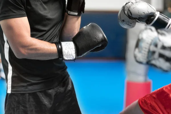 Jongeman vechter, training kick boksen met zijn trainer, vechten in de ring. — Stockfoto