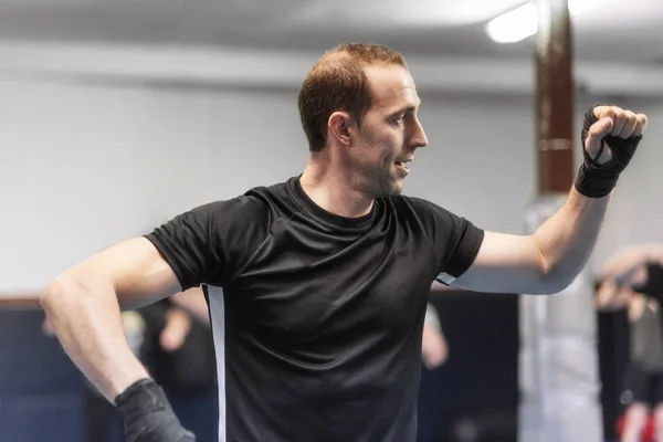 Un uomo in forma che si riscalda in palestra. Preparare il combattimento di kick boxing . — Foto Stock