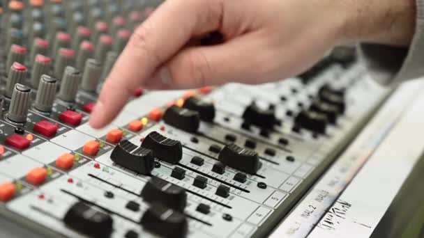 Primer plano de una consola de mezcla, director de sonido ajustando a mano los faders. Estudio de grabación profesional. Trabajar en un estudio de grabación . — Vídeo de stock