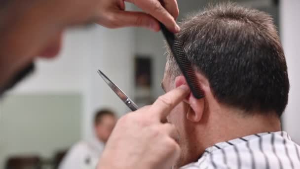 Peluquero recortar el pelo del anciano en la peluquería . — Vídeos de Stock