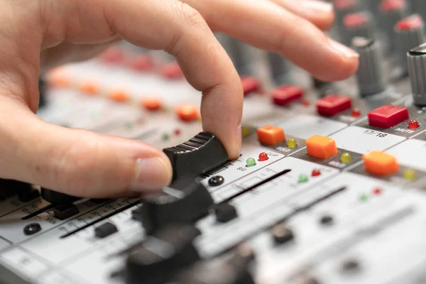 Close-up of a mixing console, hand equalizing audio channels. Professional recording studio. Working in recording studio.