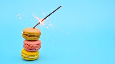 Mavi pastel arka planda yanan kıvılcımlı lezzetli makarna yığını. Kutlama konsepti.