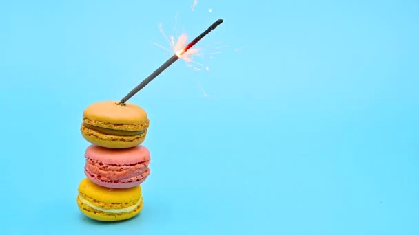 Stapel heerlijke macaron met brandende schittering op blauwe pastelachtergrond. Feestconcept. — Stockvideo