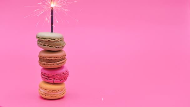 Montón de delicioso macaron con chispa ardiente sobre fondo pastel rosa. Celebrando el concepto . — Vídeos de Stock