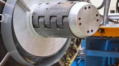 Metal levha oluşturma makinesine bağlı endüstriyel metal bobinler.