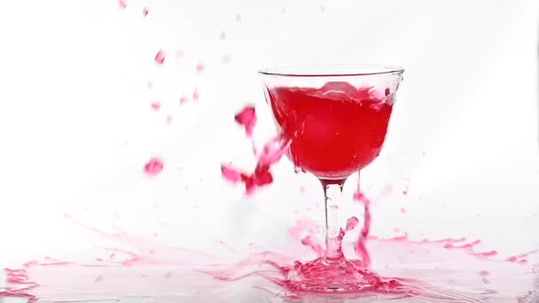 Cubo de hielo cayendo con salpicadura en rojo bebida de cóctel de alcohol fresco sobre fondo blanco, disparo en cámara lenta . — Vídeo de stock