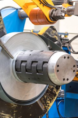 Metal levha oluşturma makinesine bağlı endüstriyel metal bobinler.