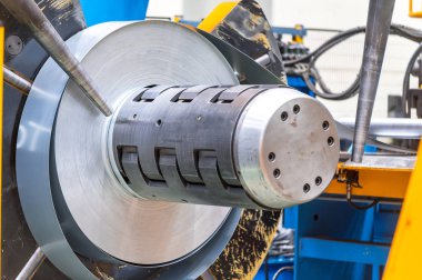 Metal levha oluşturma makinesine bağlı endüstriyel metal bobinler.