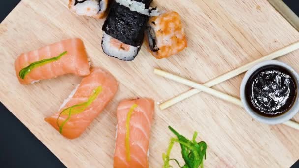 Gros plan sur divers types de sushis frais préparés japonais. Images de rotation dynamique de vue de dessus . — Video