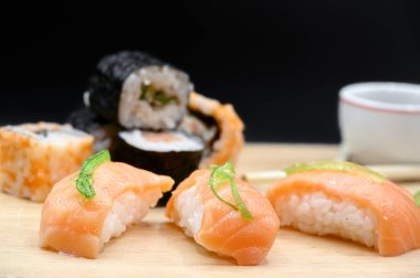 Çeşitli Japon Taze Suşi Türlerini Kapatın Ahşap masa üzerinde siyah izole edilmiş arka plan.