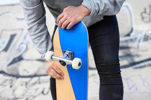 Gros plan d'un jeune homme méconnaissable tenant du longboard ou du skateboard dans le parc . — Photo