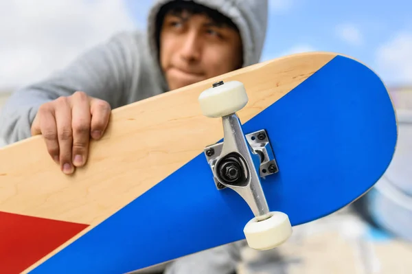 Gros plan d'un jeune homme tenant du longboard ou du skateboard dans le parc . — Photo