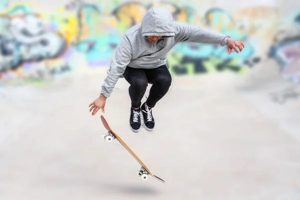 young skater doing jump trick at skate park.