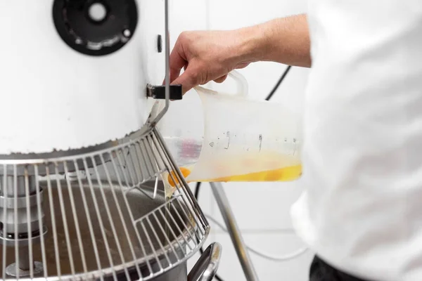 Primer plano del chef de pastelería Añadir ingrediente a la máquina de masa en la confitería . — Foto de Stock