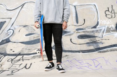 Parkta elinde kaykayla tanınmayan bir genci yakından çek..