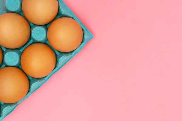 Сырые коричневые куриные яйца на розовом фоне . — стоковое фото