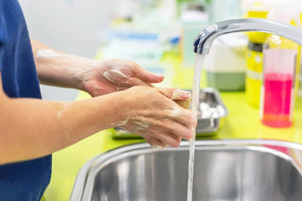 Предотвращение коронавируса. Закройте неузнаваемую медсестру, моющую руки после лечения пациента с инфекцией Ковид-19. Медицинская процедура дезинфекции . — стоковое фото